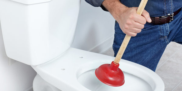 Toilette wird mit Pümpel bearbeitet